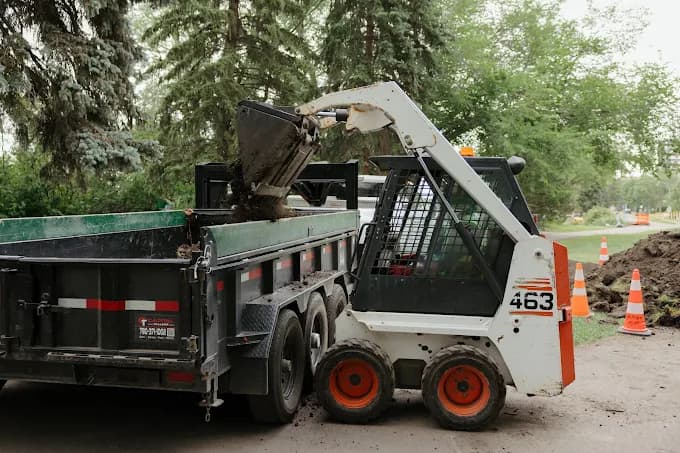 Skid-steer loading on a job site — custom software AltaPro AI builds for Alberta trades and contractors